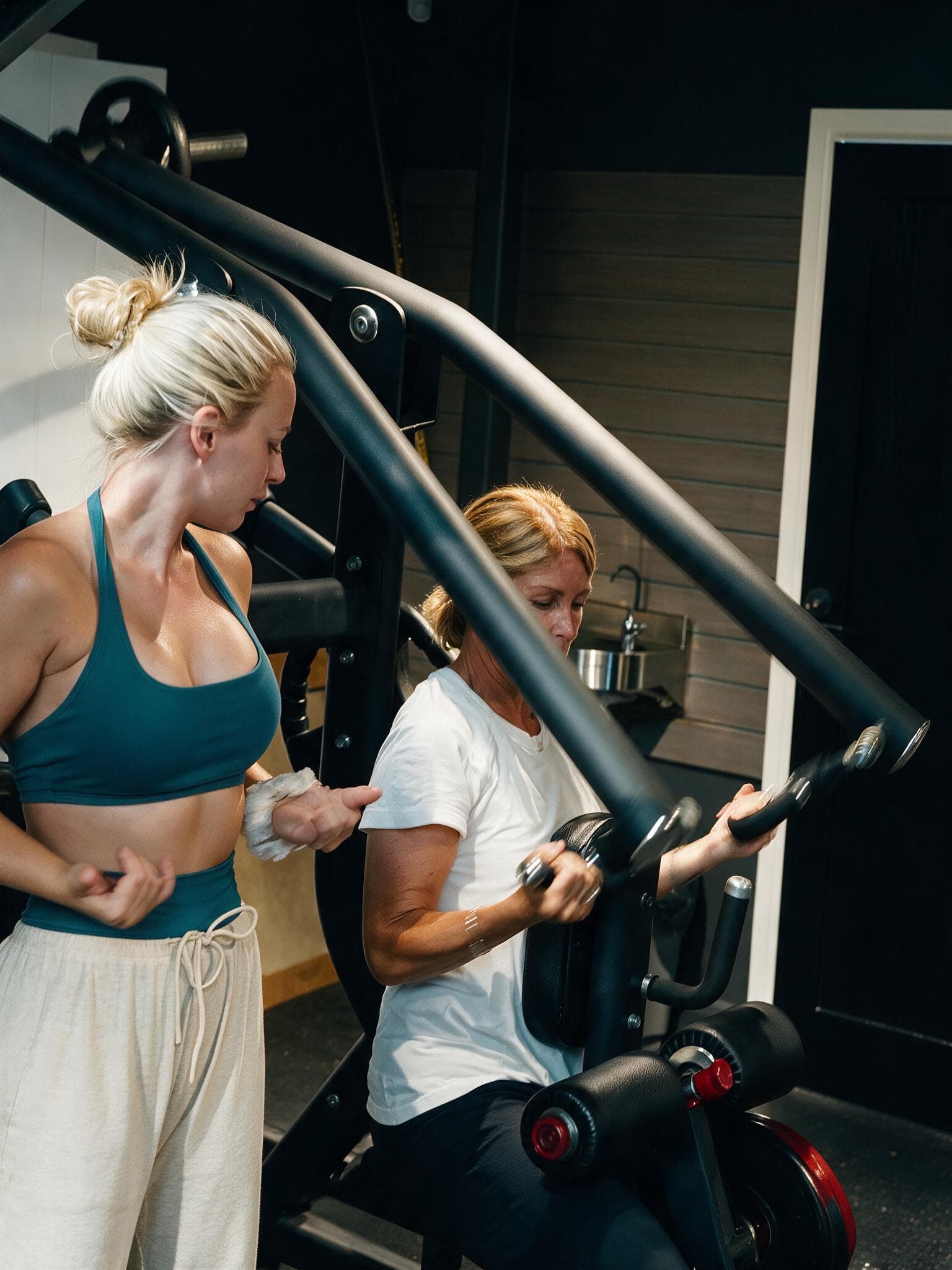 Beth guiding a client's grip through a press on the machine